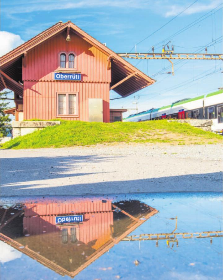 Spiegelung des Bahnhofs in einer Pfütze: Ein ruhiger Moment im Alltag.Foto: Daniel Gugelmann
